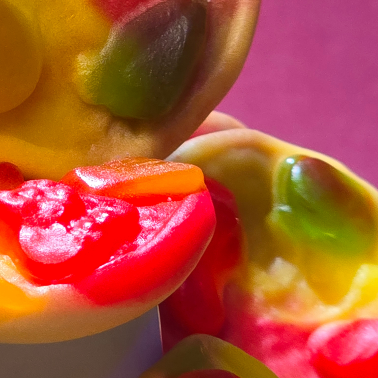 Bonbons colorés en forme de cœur, présentés dans un bol sur une table en bois.