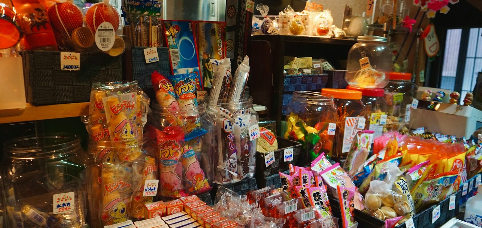 Une boutique animée avec des bonbons colorés, confiseries et décorations variées.